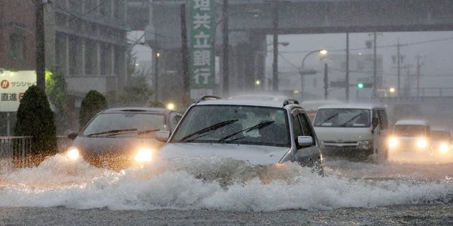 Cars manouever through flood waters on a road in Nagoya, Aichi prefecture on September 4, 2013.