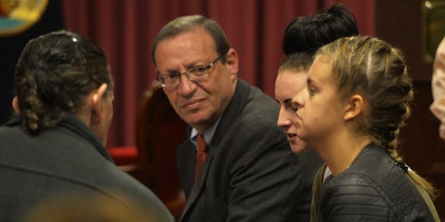 Irishwoman Michaella McCollum, 20, (C) and Briton Melissa Reid, 20, arrested at Lima's airport for carrying cocaine in their luggage, sit in a courtroom with their Peruvian lawyer Meyer Fishman (L), during a court hearing in Callao on August 21, 2013.