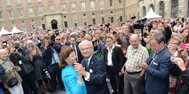 Queen Silvia and King Carl Gustaf of Sweden lead a dance in the palace courtyard in Stockholm on September 15, 2013.