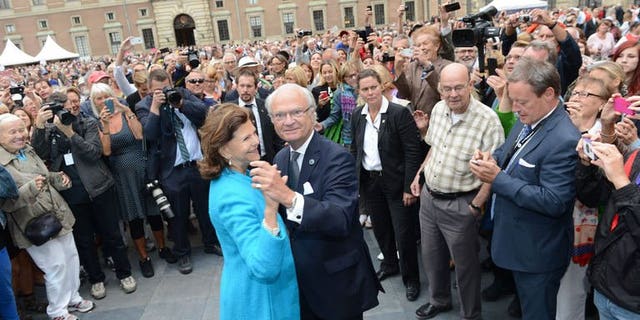 Queen Silvia and King Carl Gustaf of Sweden lead a dance in the palace courtyard in Stockholm on September 15, 2013.