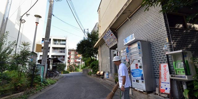 In this picture taken on September 14, 2013, 79-year-old resident Kohei Jinno sweeps and cleans a road before his apartment complex near the rebuilt national stadium in Tokyo.