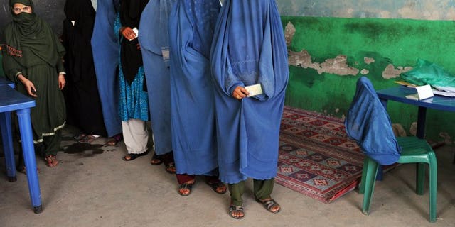 Afghan women wait in line to receive voter identification cards at a poll registration centre in Jalalabad on September 7, 2013.