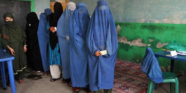Afghan women wait in line to receive voter identification cards at a poll registration centre in Jalalabad on September 7, 2013.