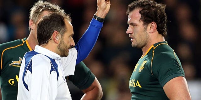 Bismarck du Plessis of South Africa (R) is yellow-carded by referee Romain Poite (L) during the Rugby Championship Test rugby union match between the New Zealand All Blacks and South Africa at Eden Park in Auckland on September 14, 2013.
