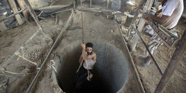 A Palestinian man is lowered into a smuggling tunnel beneath the Gaza-Egypt border, in the southern Gaza Strip, on September 11, 2013. Gaza rulers Hamas and residents of the Palestinian territory fear Egypt's destruction of tunnels used to smuggle goods across the border is part of a plan to tighten a blockade of the Strip.