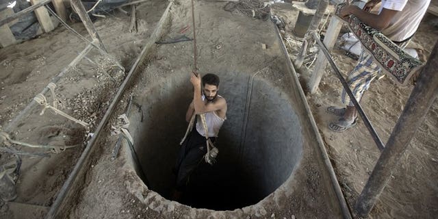 A Palestinian man is lowered into a smuggling tunnel beneath the Gaza-Egypt border, in the southern Gaza Strip, on September 11, 2013. Gaza rulers Hamas and residents of the Palestinian territory fear Egypt's destruction of tunnels used to smuggle goods across the border is part of a plan to tighten a blockade of the Strip.