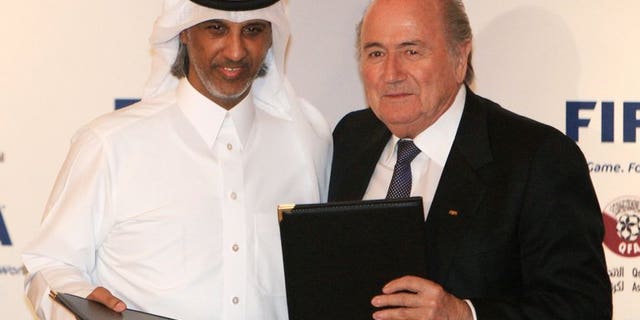 FIFA president Sepp Blatter (R) and Qatar Football Association (QFA) president, Sheikh Hamad bin Khalifa bin Ahmed al-Thani, pose with documents after officially appointing Qatar as the host of the 2022 FIFA World Cup during a function in Doha on December 16, 2010.