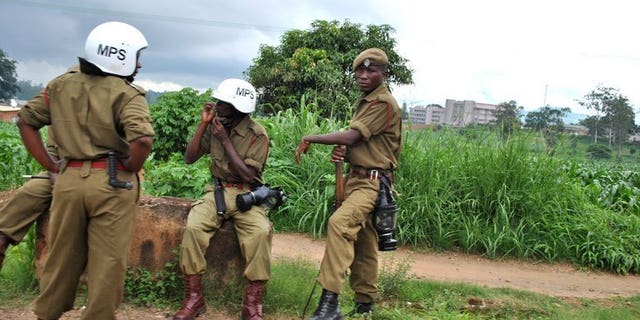 Police officers rest near a market in Blantyre on January 17, 2013. Malawi police said they have arrested three suspects in connection with the shooting of a top treasury official about to expose a corruption syndicate.