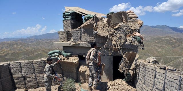 Afghan border policemen inspect a bunker destroyed during clashes between Afghan border police and Pakistani troops in Goshta district of Nangarhar province on May 8, 2013. Pakistan accused Afghan forces of killing five Pakistanis on Wednesday in cross-border "indiscriminate firing" in its southwestern Baluchistan province.