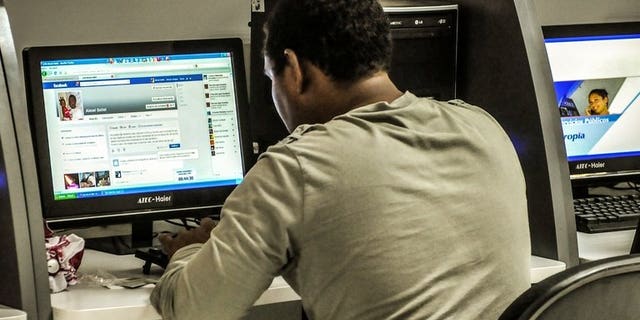 A man checks Facebook at a cyber cafe on June 4, 2013. Parents of a Canadian girl who killed herself after months of cyberbullying following a rape were sickened on Wednesday that her image was used to advertise an online dating service.