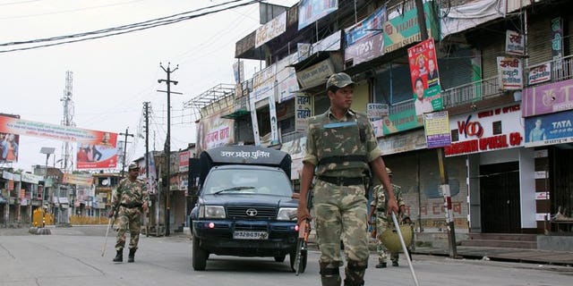 Indian soldiers patrol alongside a state police vehicle on a deserted street following communal riots between Muslims and Hindus in Muzaffarnagar, India's Uttar Pradesh state, on September 8, 2013.