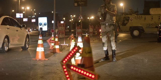 Troops keep watch at a checkpoint during the curfew hours in Cairo late on August 19. Egypt is to shorten a night-time curfew imposed on Cairo and 13 provinces starting Saturday, the cabinet said on Thursday.