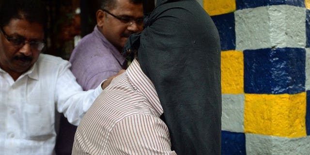 Indian police officials escort a suspect in the gang-rape of a female photographer from a crime branch unit station in Mumbai on August 26, 2013. Four men were formally charged Thursday in a Mumbai court over the gang rape of a young photographer in the city -- a case that reignited anger about women's safety across India.