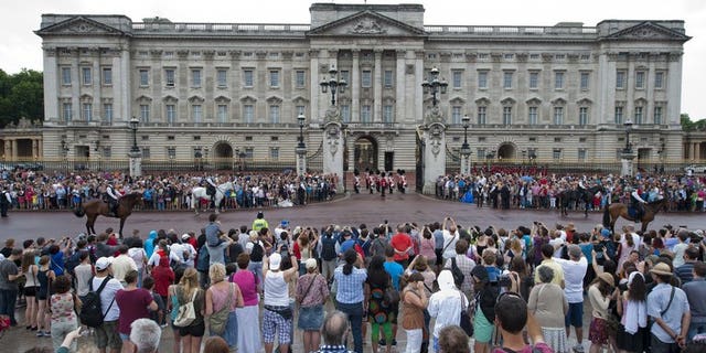Crowds gather outside Buckingham Palace on July 23, 2013. Preparations for the first football match to be staged at th palace were stepped up when a pitch was marked out in the garden.