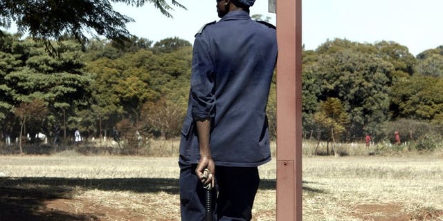 A Zimbabwean police officer stands guard in Harare on June 22, 2008. Zimbabwe's high court ordered the release of 21 opposition activists detained for over two years in connection with the death of a police officer