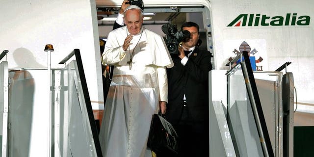 Pope Francis waves as he boards the plane after a week-long trip to Brazil, on July 28, 2013. Pope Francis on Thursday lashed out at what he called the scandal of "airport bishops", urging his peers to remain rooted in their dioceses and spend less time seeking the spotlight.