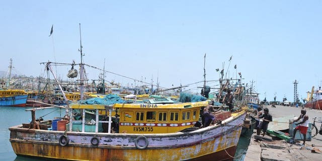 Indian fishermen work on the dockside in Visakhapatnam on April 9, 2012.