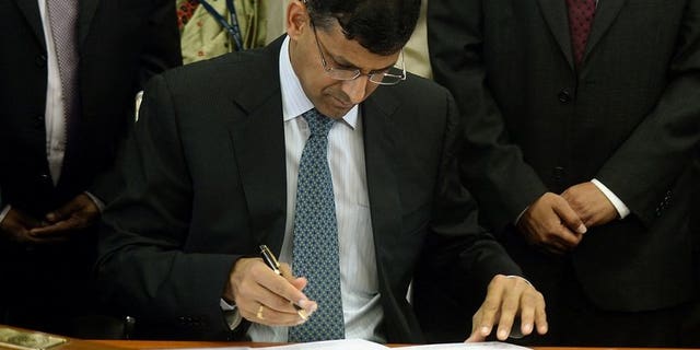 Reserve Bank of India's (RBI) newly appointed governor Raghuram Rajan signs official papers during the hand over ceremony at the RBI headquarters in Mumbai on September 4, 2013.