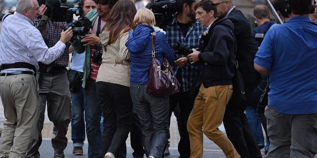 Anne (centre R) and Daniela Skinner (centre L), wife and daughter of alleged Mafia boss Domenico Rancadore, are pursued by the media, outside Westminster Magistrates court in London, on August 9, 2013.