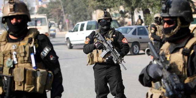 Iraqi anti-terror police stand guard at a checkpoint in Baghdad, on January 6, 2011. At least four police officers have been killed after suicide bombers attacked their base in Baiji, according to a fellow officer and a doctor.