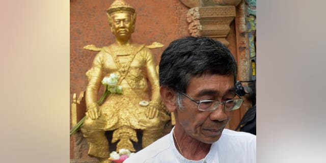 Cambodian Prince Sisowath Thomico walks past a statue of King Sisowath after praying and laying flowers during his hunger strike at Wat Phnom in Phnom Penh, on September 20, 2013. The prince has ended a hunger strike over disputed polls after military police expelled him from a pagoda where he was holding the protest fearing it would snowball.