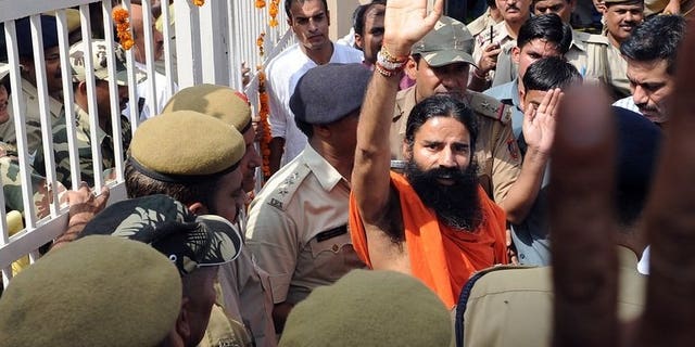 Yoga guru Swami Baba Ramdev (centre) waves to supporters of Indian social activist Anna Hazare as he comes out of Tihar prison during a protest in New Delhi on August 17, 2011. Swami Ramdev, who heads a global yoga empire, was detained Saturday at London's Heathrow airport and questioned for six hours by British customs officials, the Press Trust of India reported.