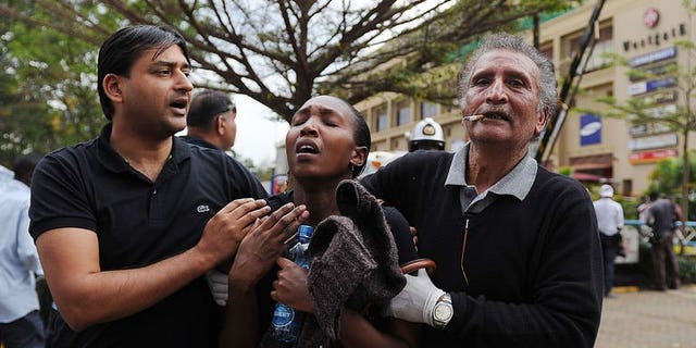 A woman (C) who had been held hostage reacts in shock on September 21, 2013 after she was freed following a security operation at an upmarket shopping mall in Nairobi where suspected terrorrists engaged Kenyan security forces in a drawn out gun fight.