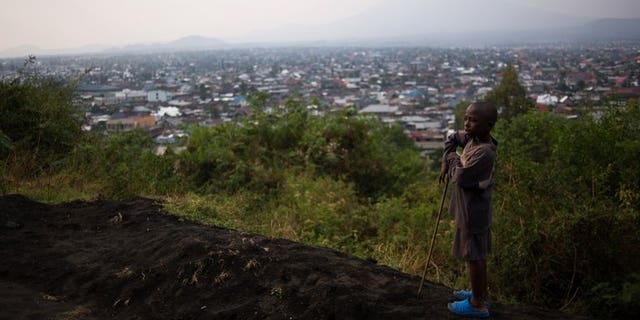 A young boy stands atop Mount Goma overlooking the capital of North Kivu province in the east of the Democratic Republic of the Congo on August 1, 2013.