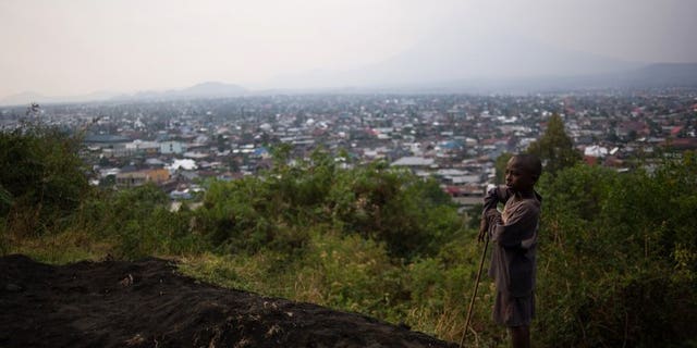 A young boy stands atop Mount Goma overlooking the capital of North Kivu province in the east of the Democratic Republic of the Congo on August 1, 2013.