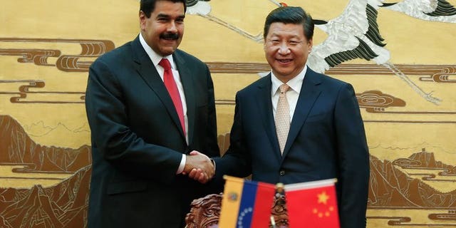 Chinese President Xi Jinping (right) shakes hands with his Venezuelan counterpart Nicolas Maduro during a signing ceremony at the Great Hall of People in Beijing, on September 22, 2013. Maduro says Beijing has granted his country a $5 billion credit line.