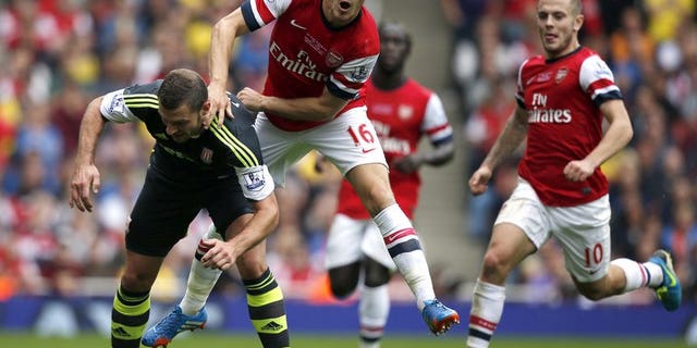 Arsenal's Aaron Ramsey (second left) and Stoke City's Erik Pieters at the Emirates Stadium, London on September 22, 2013. Arsenal went to the top of the English Premier League table after a 3-1 victory at home to Stoke on Sunday.