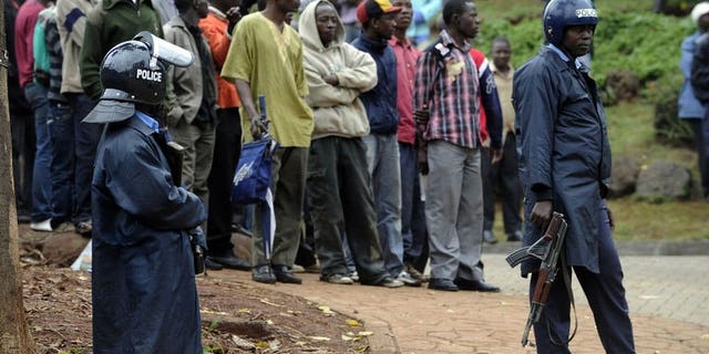 Armed Kenyan policemen keep onlookers away outside the Westgate mall in Nairobi on September 23, 2013. A fourth Briton has been confirmed killed in an attack at the shopping mall staged by Somali Islamist militants, the Foreign Office in London has said.