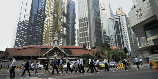 Workers head to work at Singapore's central business district on August 23, 2011. Singapore announced tighter rules on the hiring of foreign professional workers, saying companies will from next year have to show proof they first tried to recruit local citizens