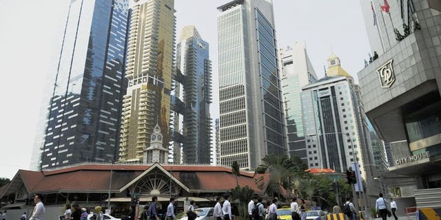 Workers head to work at Singapore's central business district on August 23, 2011. Singapore announced tighter rules on the hiring of foreign professional workers, saying companies will from next year have to show proof they first tried to recruit local citizens