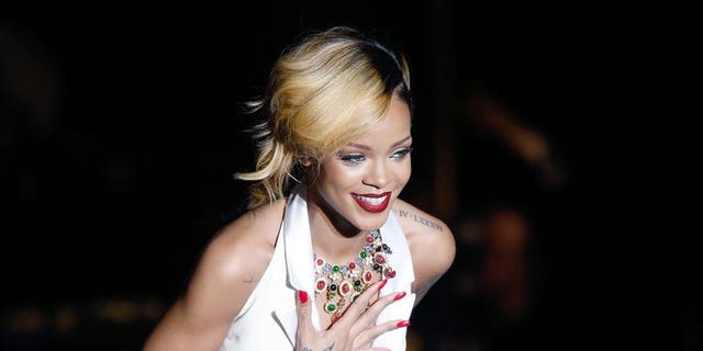 Barbadian singer Rihanna performs on stage in Monaco, on July 10, 2013. Thai authorities say two men have been arrested on suspicion of possessing a protected primate after Rihanna posted a picture of herself online holding the creature.