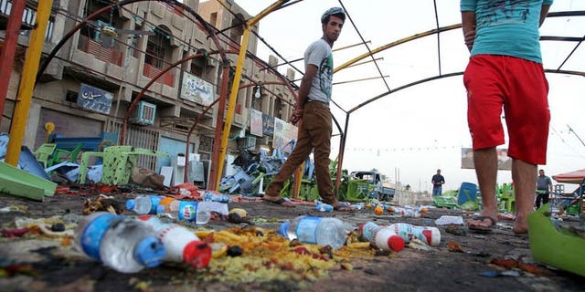 Iraqis inspect the site the day of a bombing attack near a funeral tent in the Sadr City district of Baghdad on September 22, 2103.