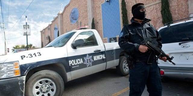 A member of the local police stands guard on January 31, 2012 in Ciudad Juarez. Gunmen armed with assault rifles opened fire on a group of people after an amateur baseball game in northern Mexico, killing 10 including a six-year-old girl, authorities said Monday.
