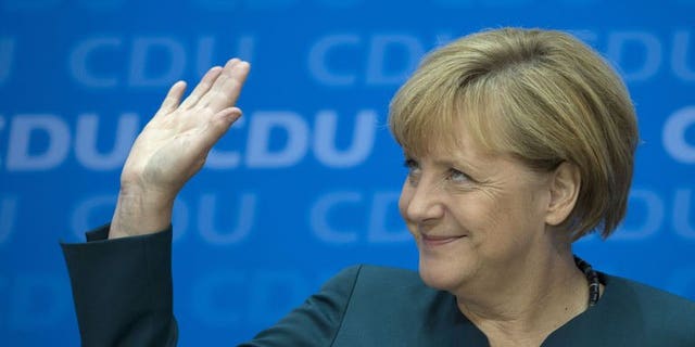 German Chancellor Angela Merkel waves as she gives a press conference in Berlin, on September 23, 2013, a day after the German general elections.
