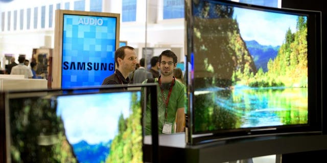 People look at curved OLED TV screens in Berlin on September 5, 2013.