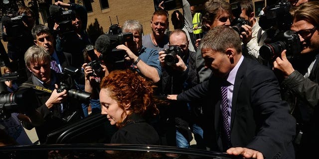 Members of the media surround former News International chief executive Rebekah Brooks in London on June 5, 2013 after attending a hearing into charges linked to the phone-hacking scandal. A member of staff at London's Metropolitan Police headquarters was one of two people arrested on Tuesday as part of a bribery investigation sparked by the phone-hacking scandal at the News of the World tabloid.