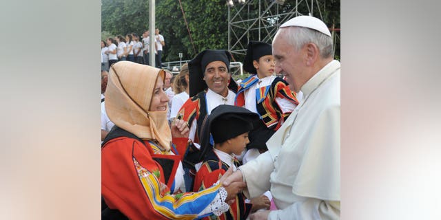 Pope Francis meets worshippers during a visit to Cagliari, on September 22, 2013. Pope Francis has called on countries to protect migrants, condemning the treatment of refugees as mere "pawns on the chessboard of humanity".