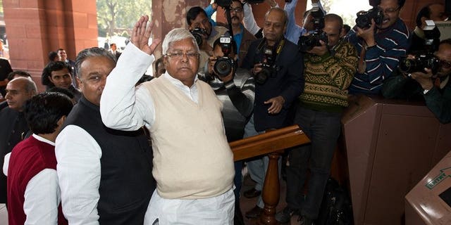 Former Railway Minister Lalu Prasad Yadav (C) arrives at Parliament for the unveiling of the Railway Budget in New Delhi on February 26, 2013.