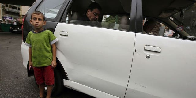A Syrian refugee child from the northern city of Aleppo sells chewing gum in a traffic jam on a street in the Lebanese capital, Beirut, on Spetember 18, 2013.