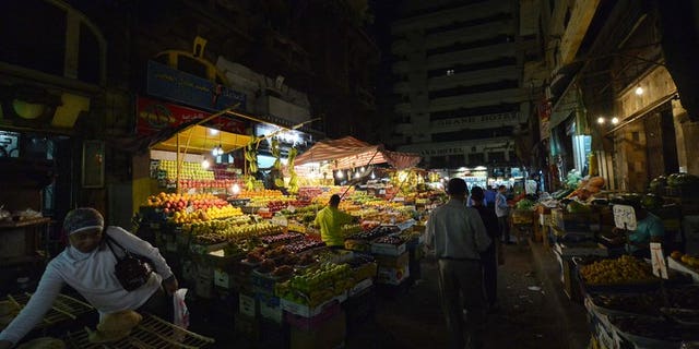 Egyptians walk at a fruit market in downtown Cairo on October 18, 2012. Egypt will impose a sharp cut in the price of fruits and vegetables if they do not come down on their own by next week, the supply and domestic trade minister said Tuesday.