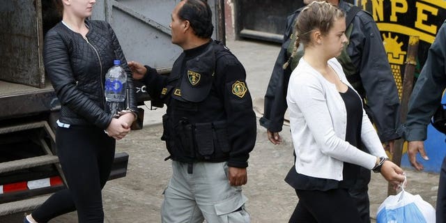 Irishwoman Michaella McCollum (L) and Briton Melissa Reid (R) walk into the Sarita Colonia Jailhouse Court in the port of Callao, west of Lima, on September 24, 2013, where both pleaded guilty to attempting to sneak 11 kilos of cocaine out of the country and into Spain