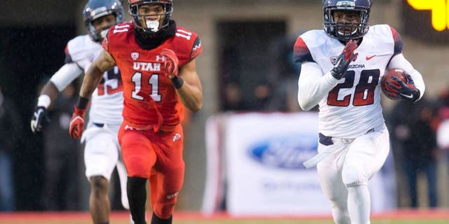 Nov 22, 2014; Salt Lake City, UT, USA; Arizona Wildcats running back Nick Wilson (28) runs with the ball up the sideline while pursued by Utah Utes defensive back Davion Orphey (11) during the first half at Rice-Eccles Stadium. Mandatory Credit: Russ Isabella-USA TODAY Sports