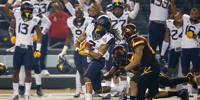 West Virginia wide receiver Ka'Raun White (2) pulls in a pass as Arizona State defensive back Kweishi Brown (10) gives chase during the first half of the Cactus Bowl NCAA college football game, Saturday, Jan. 2, 2016, in Phoenix. (AP Photo/Ross D. Franklin)