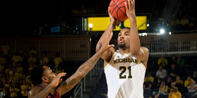 IUPUI guard Darell Combs, left, defends a jump shot from Michigan guard Zak Irvin (21) in the second half of an NCAA college basketball game at Crisler Center in Ann Arbor, Mich., Sunday, Nov. 13, 2016. Michigan won 77-65. (AP Photo/Tony Ding)