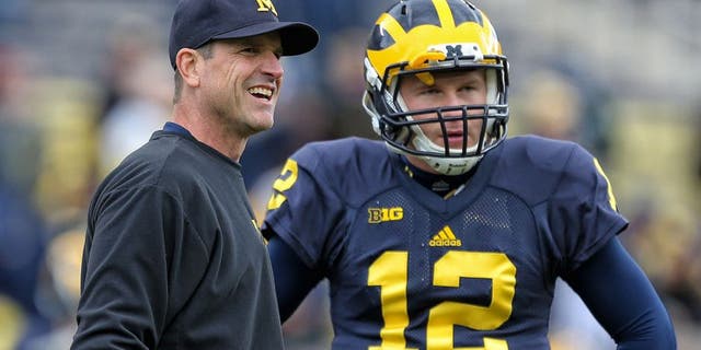 Oct 17, 2015; Ann Arbor, MI, USA; Michigan Wolverines head coach Jim Harbaugh talks to Michigan Wolverines quarterback Alex Malzone (12) prior to a game against the Michigan State Spartans at Michigan Stadium. Mandatory Credit: Mike Carter-USA TODAY Sports