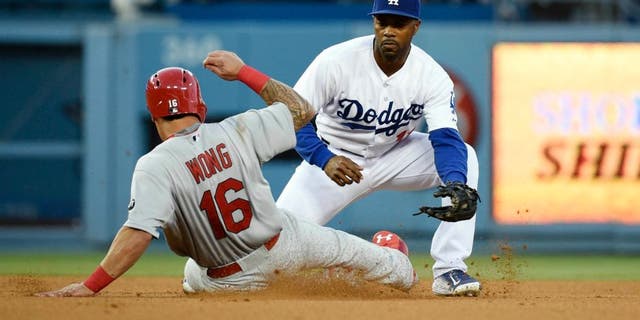 Jun 5, 2015; Los Angeles, CA, USA; St. Louis Cardinals second baseman Kolten Wong (16) is tagged out by Los Angeles Dodgers shortstop Jimmy Rollins (11) in the third inning during the game at Dodger Stadium. Mandatory Credit: Richard Mackson-USA TODAY Sports